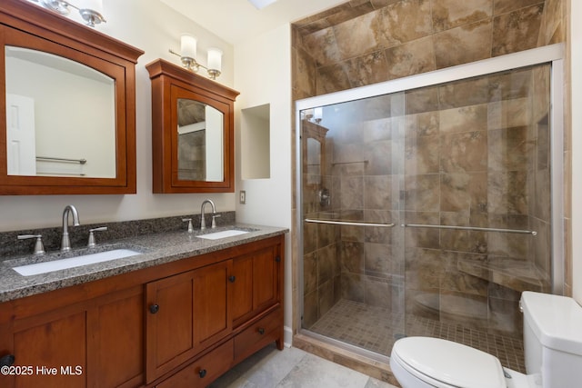 bathroom with vanity, toilet, a shower with door, and tile patterned flooring