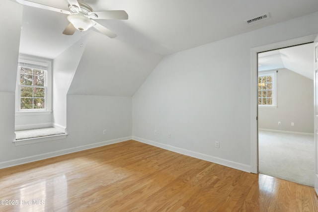 bonus room featuring vaulted ceiling, a healthy amount of sunlight, light hardwood / wood-style flooring, and ceiling fan