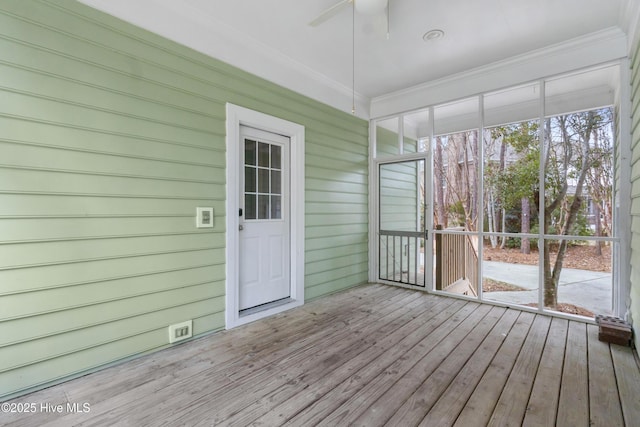 unfurnished sunroom featuring ceiling fan