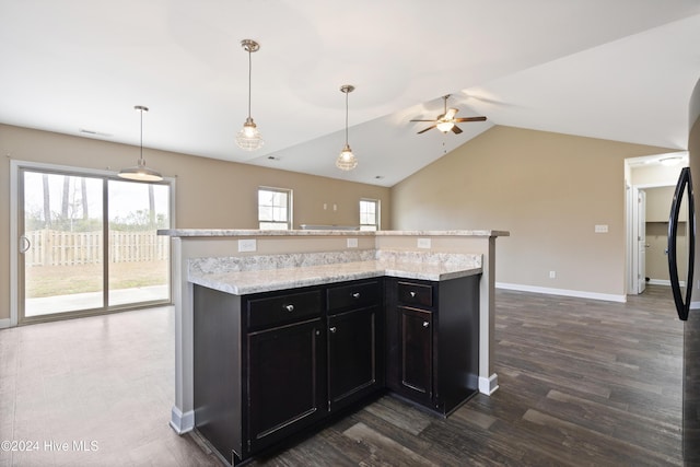 kitchen featuring decorative light fixtures, a kitchen island, dark hardwood / wood-style floors, and plenty of natural light