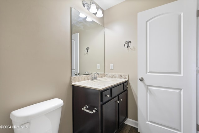 bathroom featuring hardwood / wood-style flooring, vanity, and toilet