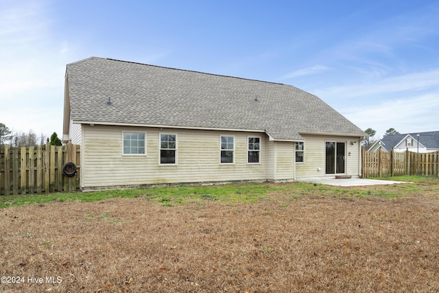 back of property with a patio area and a lawn