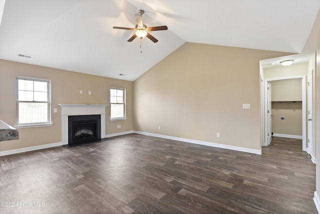 unfurnished living room featuring plenty of natural light, ceiling fan, dark hardwood / wood-style flooring, and vaulted ceiling