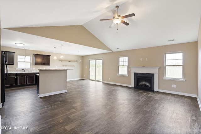 unfurnished living room with dark hardwood / wood-style floors, ceiling fan, lofted ceiling, and sink