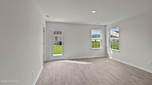 spare room with light wood-type flooring and baseboards