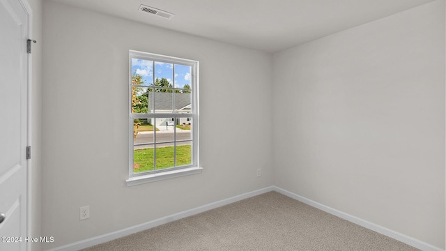 empty room featuring carpet flooring, visible vents, and baseboards