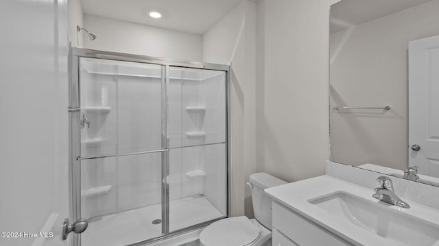 bathroom with toilet, a stall shower, and vanity