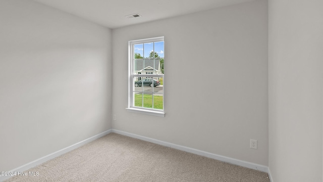 carpeted empty room featuring visible vents and baseboards