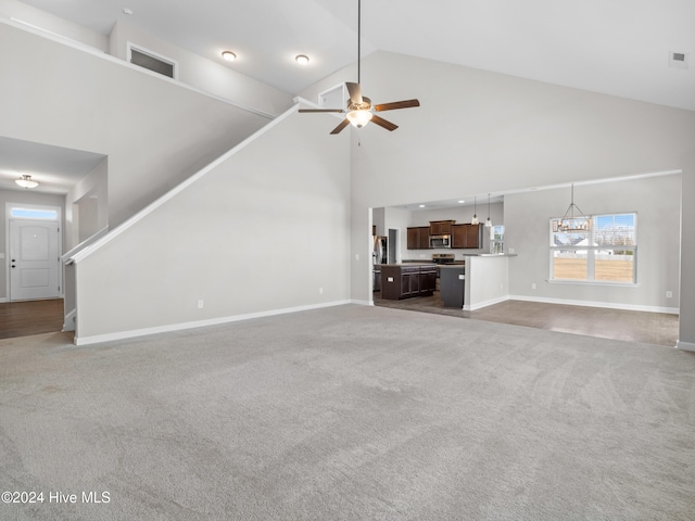 unfurnished living room featuring carpet floors, ceiling fan, and high vaulted ceiling