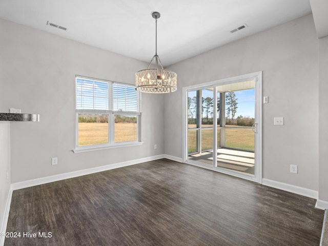 unfurnished dining area with a chandelier, dark hardwood / wood-style flooring, and a wealth of natural light