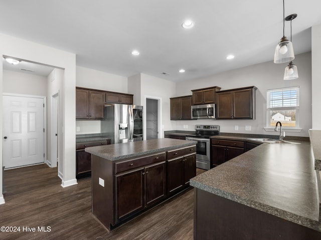 kitchen featuring a center island, hanging light fixtures, sink, appliances with stainless steel finishes, and dark hardwood / wood-style flooring