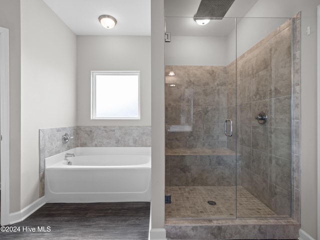 bathroom featuring shower with separate bathtub and hardwood / wood-style floors