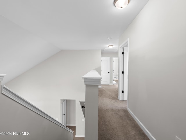 corridor with light colored carpet and vaulted ceiling