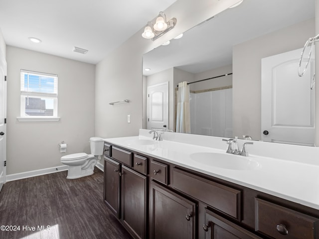 bathroom with a shower with shower curtain, wood-type flooring, vanity, and toilet