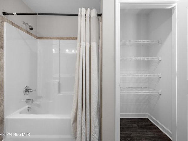 bathroom with wood-type flooring and shower / bath combo with shower curtain