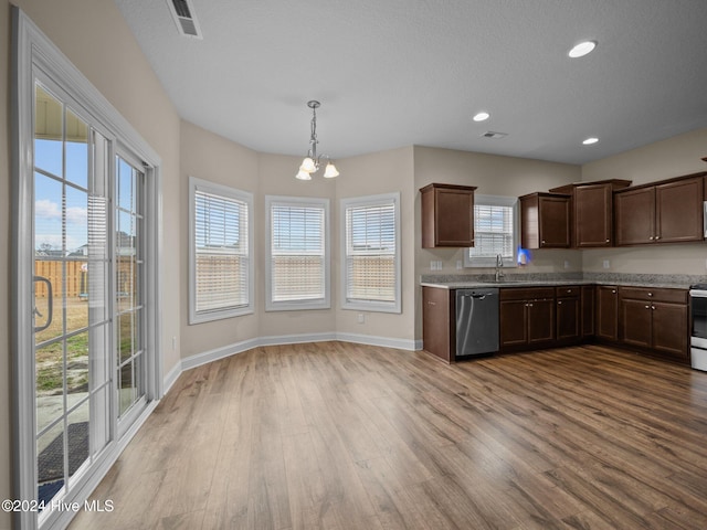 kitchen featuring plenty of natural light, light hardwood / wood-style floors, stainless steel appliances, and an inviting chandelier