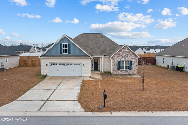 view of front of home with cooling unit, a front yard, and a garage