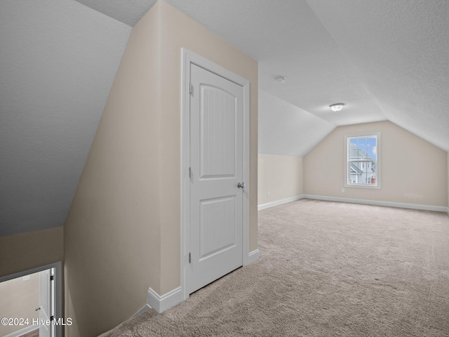 bonus room featuring carpet flooring, a textured ceiling, and lofted ceiling