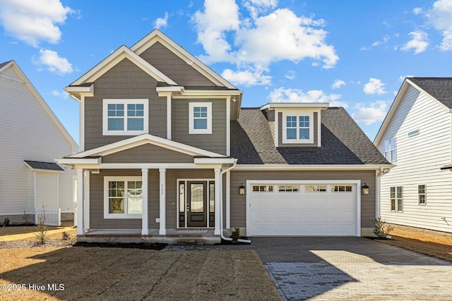 view of front of house with a porch, a garage, and central AC