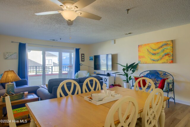 living room with a textured ceiling and light wood-type flooring