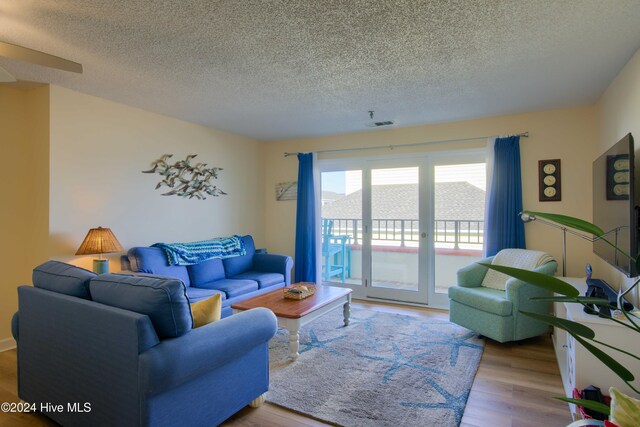 living room featuring french doors, a textured ceiling, and hardwood / wood-style flooring