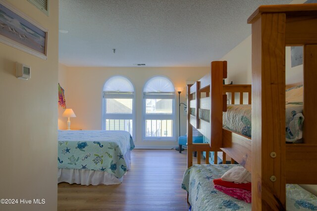 bedroom featuring a textured ceiling and hardwood / wood-style flooring