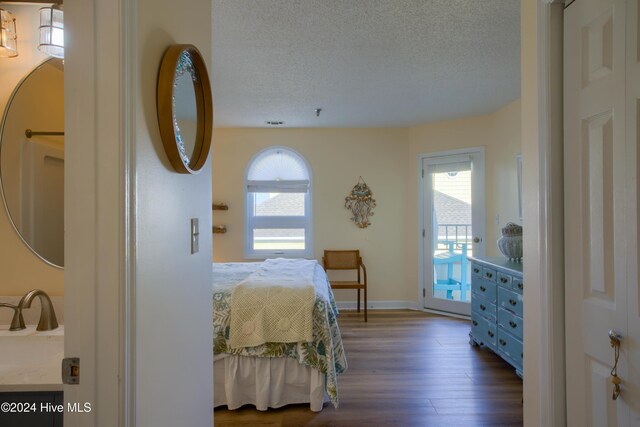 bedroom featuring a textured ceiling, access to outside, and light hardwood / wood-style floors