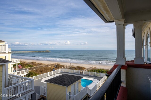 balcony featuring a water view and a beach view