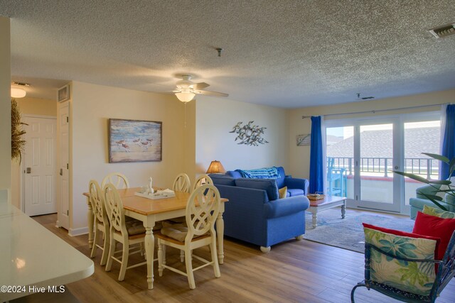 living room with french doors, hardwood / wood-style floors, and a textured ceiling