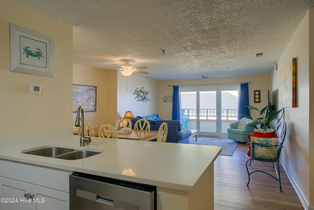 kitchen with a textured ceiling, ceiling fan, light hardwood / wood-style floors, and sink