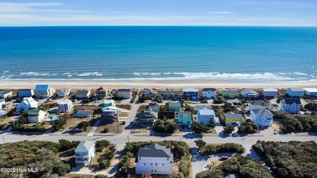 drone / aerial view featuring a residential view, a water view, and a beach view