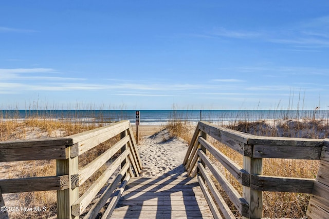 surrounding community with a water view and a beach view