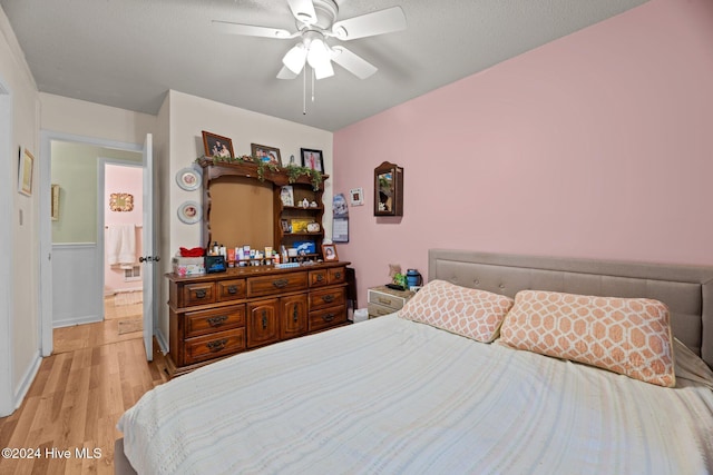 bedroom featuring ceiling fan, light hardwood / wood-style floors, and a textured ceiling