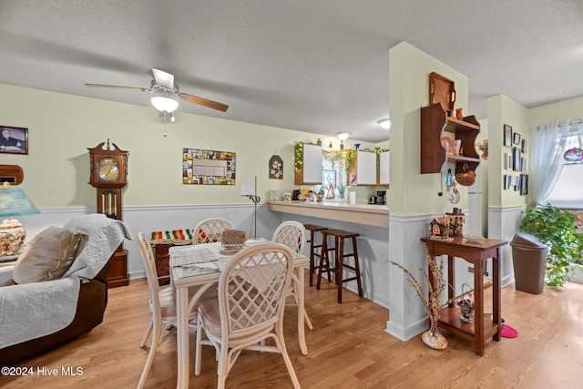 dining room with a textured ceiling, light hardwood / wood-style floors, and ceiling fan