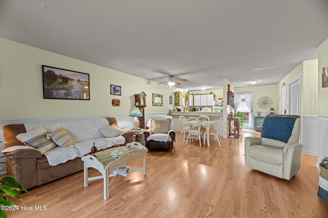 living room with light hardwood / wood-style floors and ceiling fan