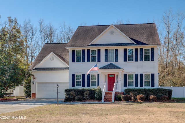 colonial inspired home featuring a front lawn and a garage