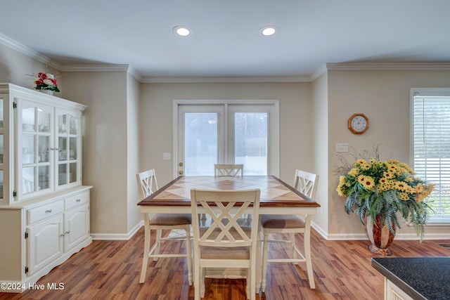 dining area featuring light wood-type flooring and ornamental molding