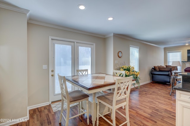 dining space with light hardwood / wood-style floors and ornamental molding