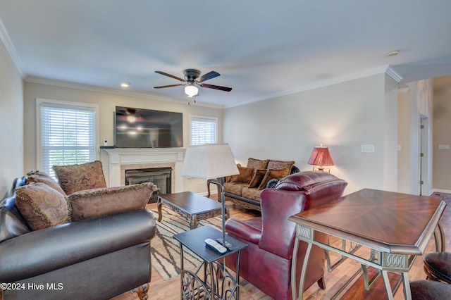 living room featuring light wood-type flooring, ceiling fan, and crown molding