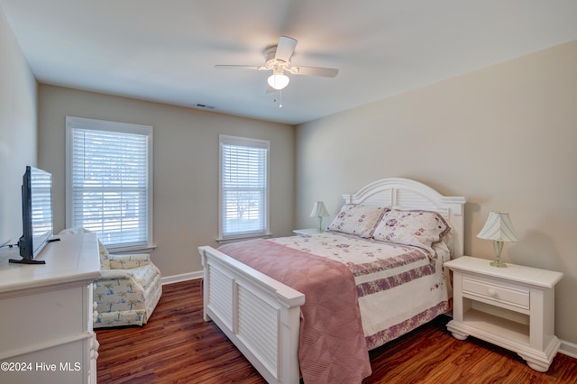 bedroom featuring multiple windows, ceiling fan, and dark hardwood / wood-style flooring