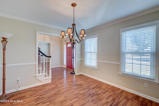 interior space with hardwood / wood-style floors, a notable chandelier, and ornamental molding