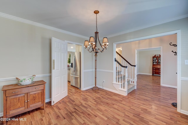 unfurnished dining area with ornamental molding, light hardwood / wood-style floors, and a notable chandelier