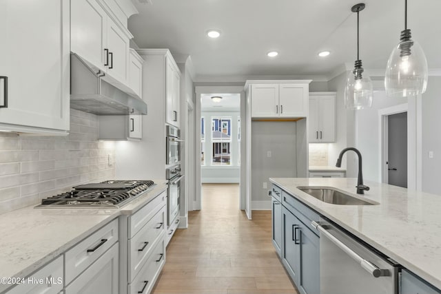 kitchen with white cabinetry, sink, stainless steel appliances, and hanging light fixtures