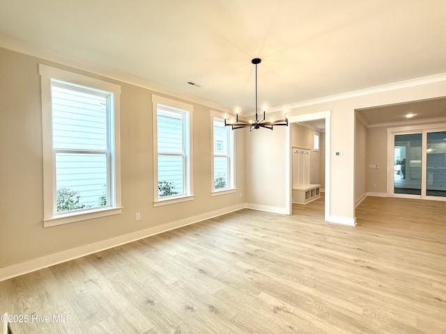 unfurnished dining area featuring light wood-style floors, a chandelier, baseboards, visible vents, and ornamental molding