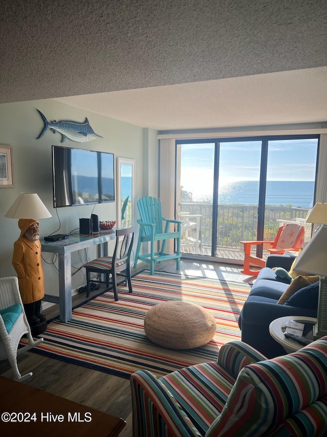 living room with wood-type flooring, a textured ceiling, and a water view