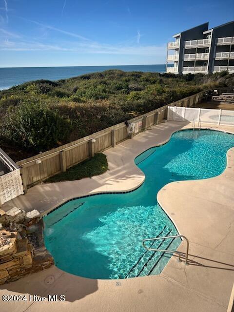 view of pool with a patio area and a water view