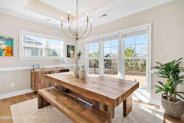 dining area featuring a wealth of natural light, crown molding, light hardwood / wood-style floors, and a notable chandelier