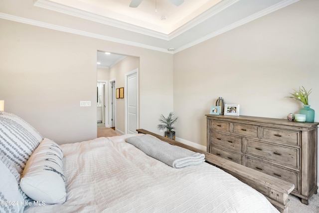 carpeted bedroom with ceiling fan, ornamental molding, and a tray ceiling