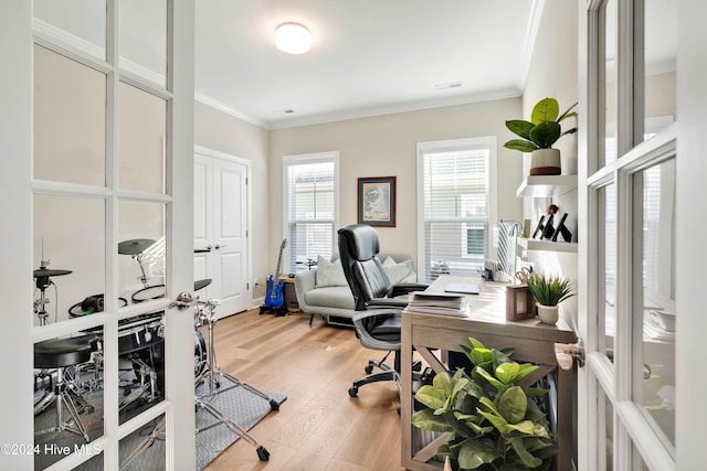 home office with light hardwood / wood-style floors and crown molding