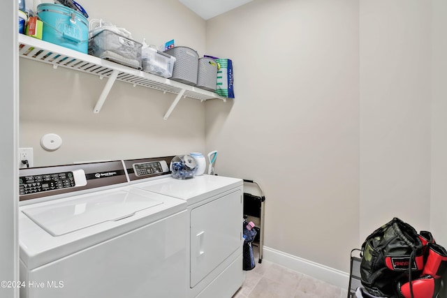 washroom featuring washing machine and dryer and light tile patterned floors